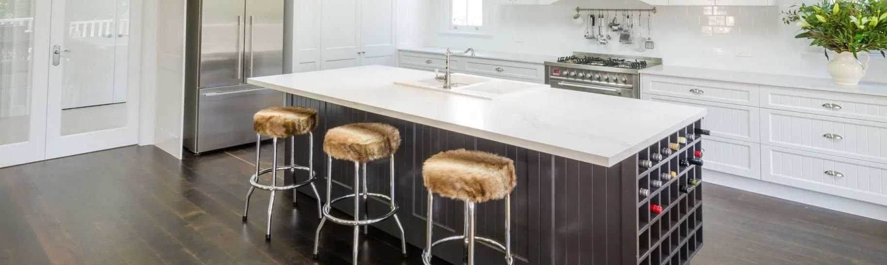 Custom Hamptons kitchen with a marble waterfall island and dark beadboard cabinetry, built by Kitchen Envy in Sydney