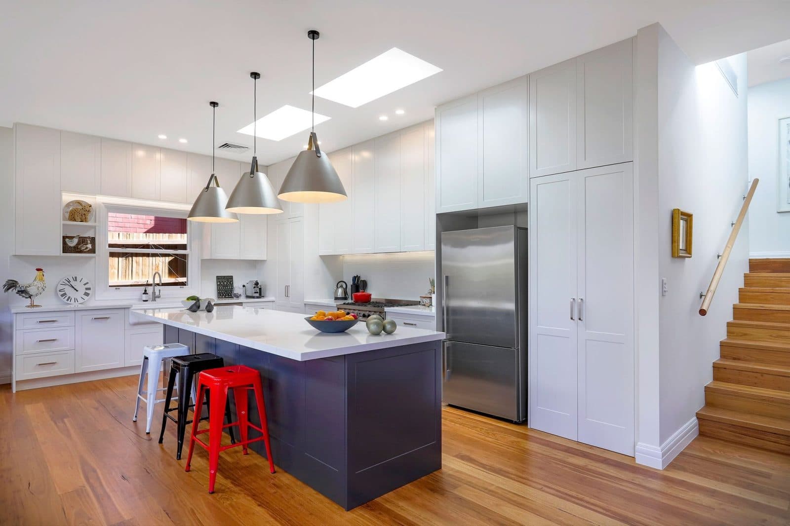 Custom Hamptons kitchen with navy island and pendant lighting by Kitchen Envy